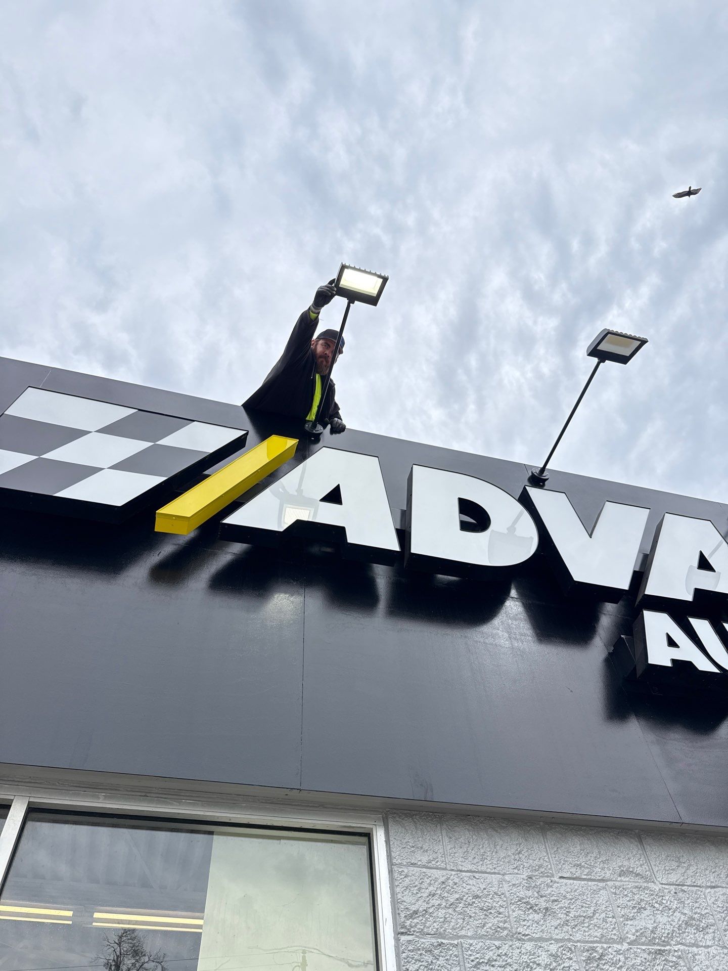 Advance Auto Parts sign with lights being installed by Apex Employee